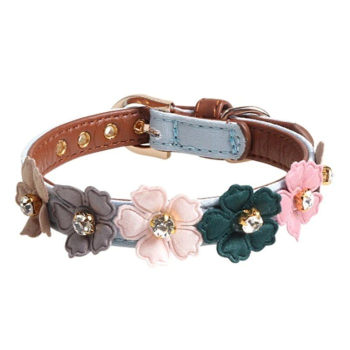 A leather bracelet with gold-colored studs and multi-colored flowers, each with a central rhinestone. The diamond flower accents are pink, green, and beige. This adjustable bracelet has a buckle closure (Product Name: 10014-a67486.jpg).