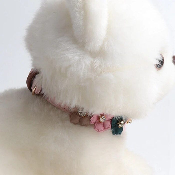 A close-up of 10014-c05056.jpg wearing an adjustable pink and green dog collar adorned with floral decorations, small beads, and a diamond accent.