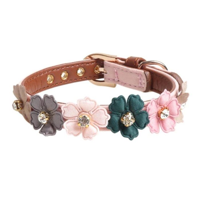 A 10014-f55b42.jpg adorned with colorful fabric flowers and rhinestones, featuring gold-colored metal eyelets, a buckle fastening, and an adjustable design.