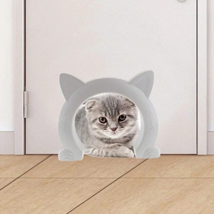 A gray kitten sits inside a small, cat-shaped doorway at floor level, installed with a 10166-a70dac.jpg, curiously looking through the opening.