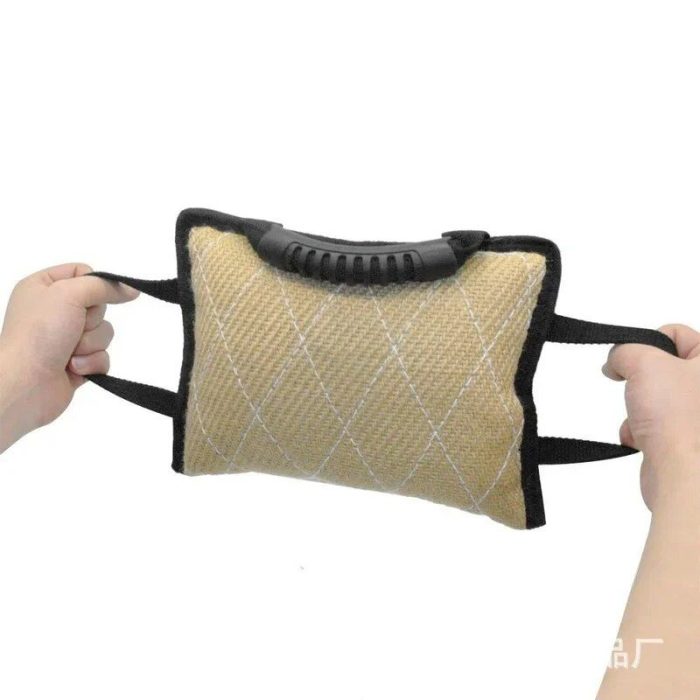 A person is holding a rectangular 10178-44b341.jpg with dual rope handles and a beige, diamond-stitched surface.