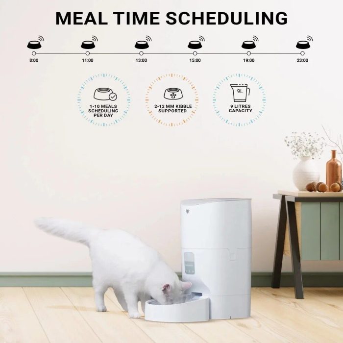 A white cat eats from a 10266-2ef71d.jpg in a minimalist room. Above, a chart shows meal time scheduling at 8:00, 11:00, 13:00, 15:00, 19:00, and 23:00 hours. The feeder features interactive app control for convenient programming and monitoring.