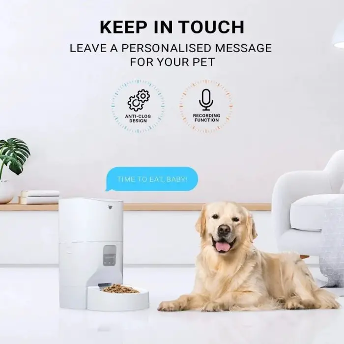 A golden retriever sits next to an automatic smart pet feeder (10266-d85752.jpg) in a white room. The feeder displays the message, "TIME TO EAT, BABY!" The image highlights features like anti-clog design, voice recording function, and interactive app control.