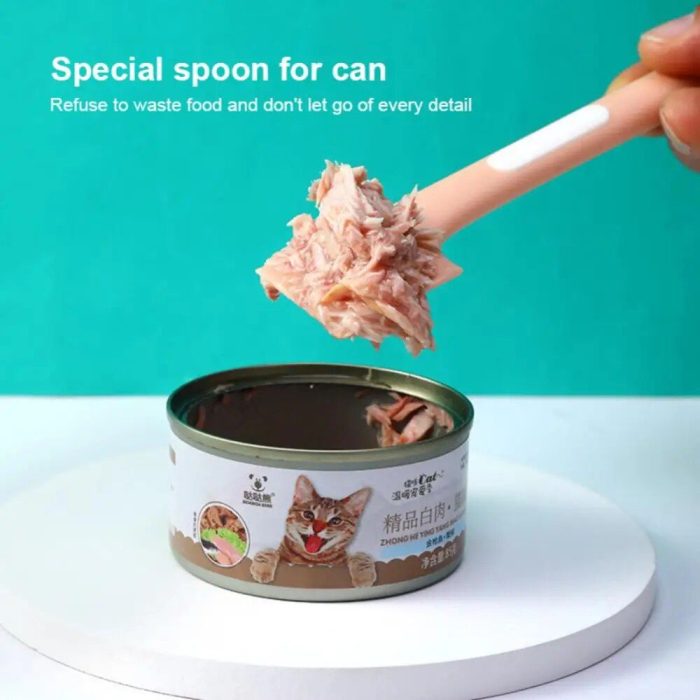 A pink spoon scooping out some food from an open can of cat food. The can has an image of a cat on its label, and there's a message above that reads, "10307-32d298.jpg.