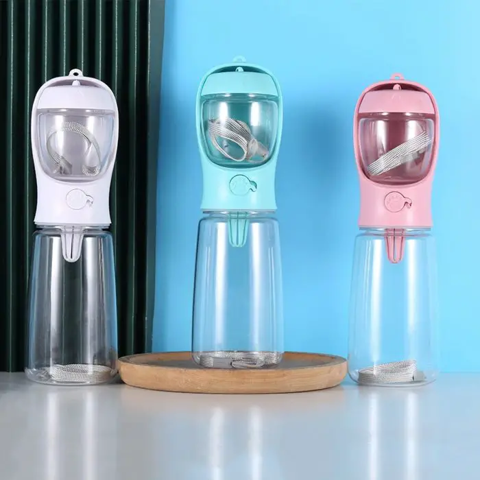 Three 10329-6bfb5a.jpg in white, blue, and pink are placed side by side on a table. Each bottle has an integrated water dispenser with a metal strap inside.