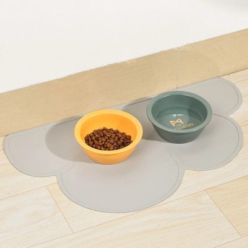 Two pet food bowls, one yellow with kibble and one green with water, are placed on a 10468-42015d.jpg on a light wood floor near a wall.