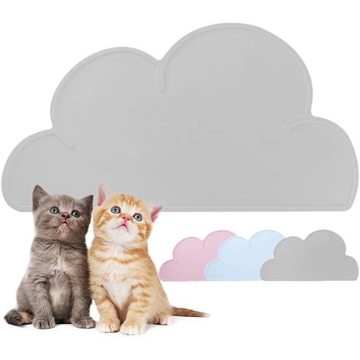 Two kittens, one gray and one orange, sit on a 10468-46ff09.jpg in front of a large cloud-shaped backdrop with smaller pink, blue, and gray cloud cutouts.