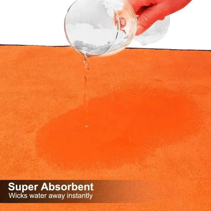 Hand pouring water onto an orange super absorbent cloth. Text on the image reads "10661-56a552.jpg: Wicks water away instantly.