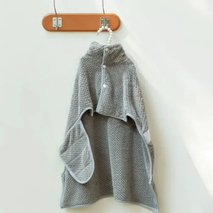 A 10726-5ca424.jpg, reminiscent of a cozy bathrobe, is hanging on a wooden peg on a white wall.