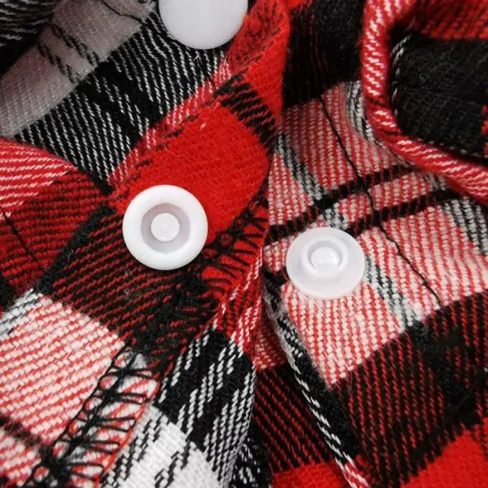 Close-up of a red, black, and white plaid fabric adorned with two white buttons (Product Name: 10834-c7d66f.jpg).