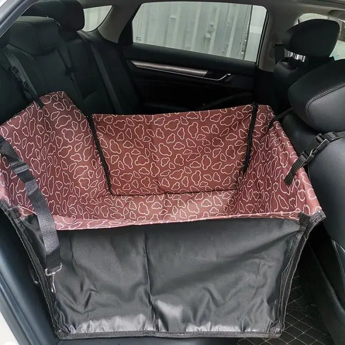 A car backseat with a red, heart-patterned 11084-4853ed.jpg securely installed, designed to protect the seat while providing a comfortable area for a pet.