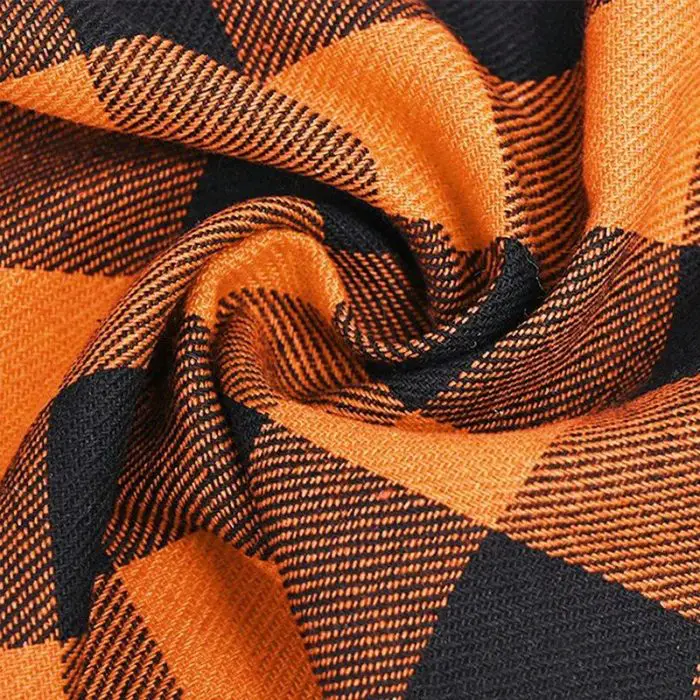 Close-up of the 11881-9f4b29.jpg bandana revealing its twisted orange and black checkered design with detailed texture and pattern.