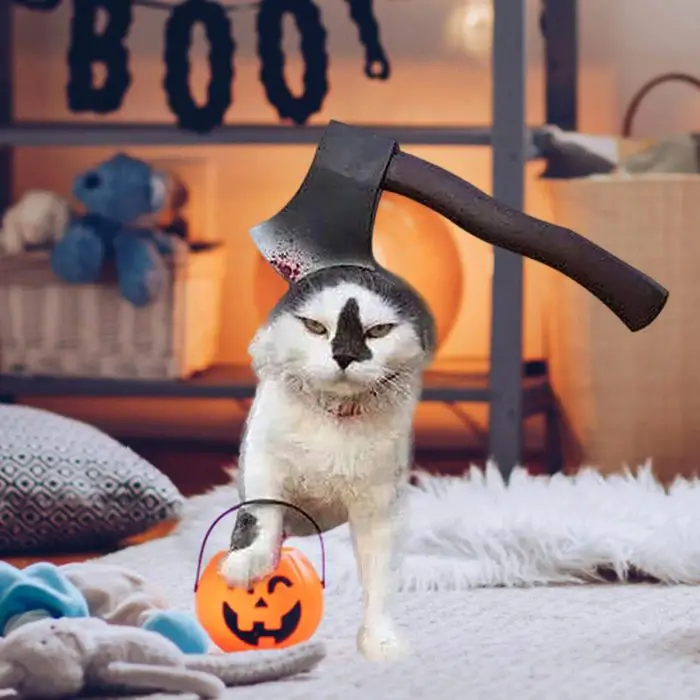 A cat donning the 12314-0f7d91.jpg costume, complete with an attached faux axe on its head, clutches a pumpkin-shaped Halloween treat bucket in its mouth. Behind it, a room is festively adorned with Halloween decorations.