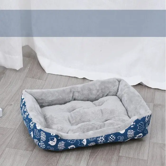 A pet bed (product code: 12442-5ea8a6.jpg) featuring a soft gray cushion and blue sides adorned with white owl patterns is perfectly placed on a wooden floor.