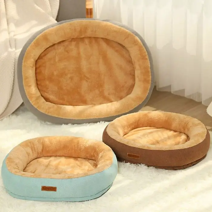 In the image "12447-b69082.jpg," three cozy pet beds are displayed: a large oval-shaped pet bed is positioned at the back, while two smaller round beds, one in blue and one in brown, are placed at the front. All of these pet beds are crafted from soft fabric.