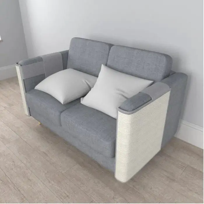 A gray upholstered loveseat featuring two light gray cushions, positioned on a light-colored wooden floor against a plain white wall, complemented by a stylish cat scratching pad. (Product: 12695-2e7692.jpg)