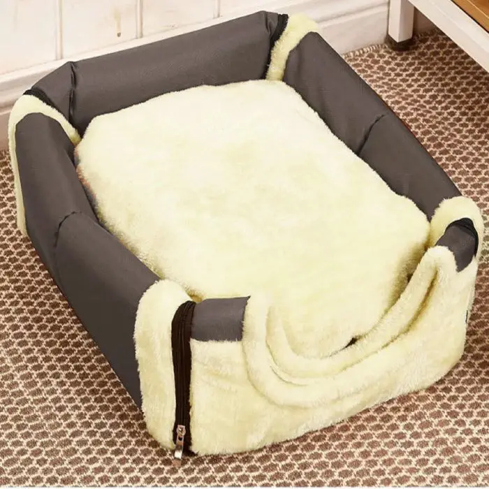 Rectangular pet bed with raised sides, featuring a soft, light cream-colored cushion and dark gray outer fabric, resembling a cozy Dog House, placed on a patterned carpet in a room can be identified as product 12748-2b6b87.jpg.