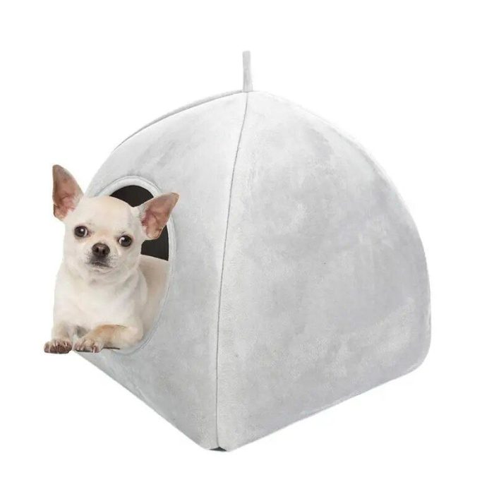 A small white dog is peeking out from a circular opening of the 12749-d16b4e.jpg gray, dome-shaped pet tent.