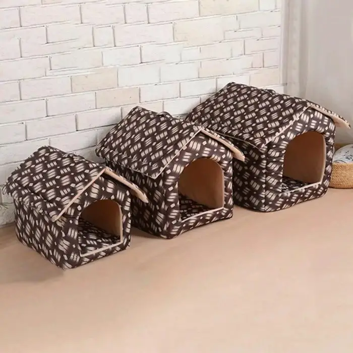 Three brown, patterned, foldable pet houses of varying sizes (Product Name: 12785-3d4879.jpg) are arranged in a row against a white brick wall on a wooden floor.