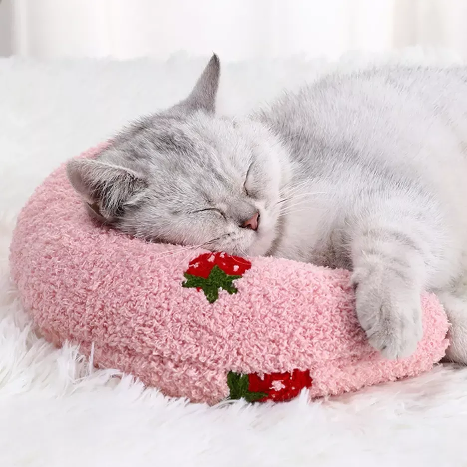 A gray cat sleeps on a 9508-7d7463.webp, lying on a white, fluffy surface. Nearby, small dogs play quietly.