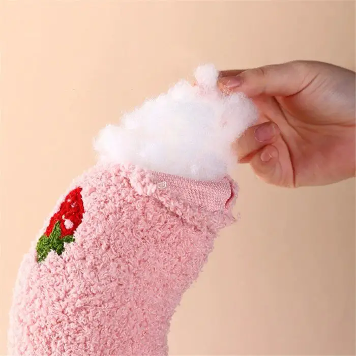 A hand is shown stuffing white cotton filling into a pink, textured U-shape plush pillow with a strawberry design on it, perfect for small dogs and cats, named 9508-e2d20f.jpg.