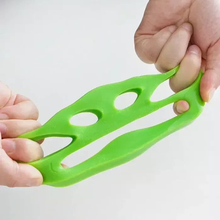 Two hands stretch a green rubber toy with holes, making it look like a face with eyes and a mouth. This eco-friendly, reusable 9573-b9b981.webp is not only fun but can also double as an effective pet hair remover.